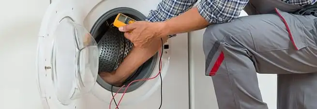 Dryer repair technician inspecting and repairing a clothes dryer in Louisville, KY