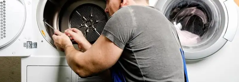 Dryer repair technician fixing a clothes dryer drum in Louisville, KY