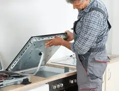 Appliance repair technician installing a built-in cooktop in Louisville, KY