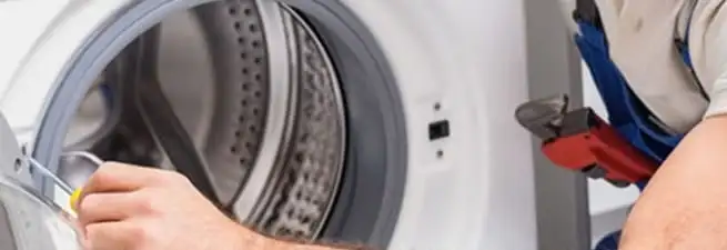 Appliance technician repairing a clothes dryer drum and internal parts in Louisville, KY