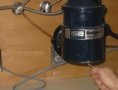 Garbage disposal repair technician tightening the mounting ring under a sink in Louisville, KY