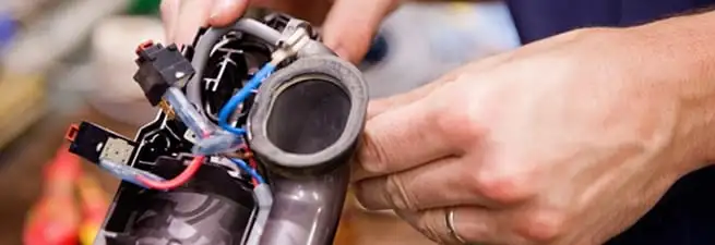 Vacuum repair technician reconnecting wiring and components in Louisville, KY