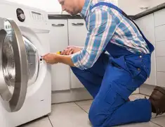 Washing machine repair technician servicing a front-load washer in Louisville, KY