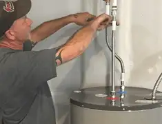 Water heater repair technician tightening supply line connections in Louisville, KY