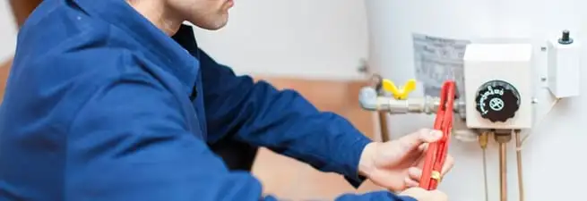 Water heater repair technician adjusting the temperature control and gas valve in Louisville, KY